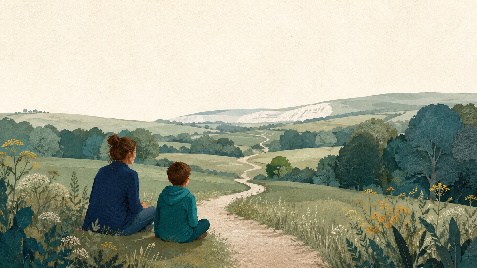 A parent and child sit together beside a winding path through green hills.